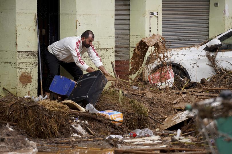 A man cleans his house affected by floods.