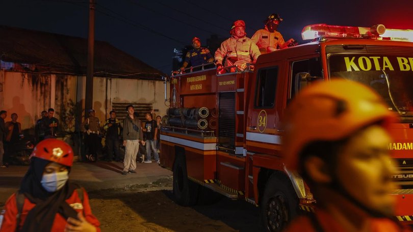 About 20 firefighting trucks are at the site of a large fire at a cooking oil factory near Jakarta. 