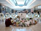  A shopper lays a floral tribute at a memorial site during the re-opening of the Westfield Bondi Junction shopping centre on April 19, 2024 in Sydney, Australia. 