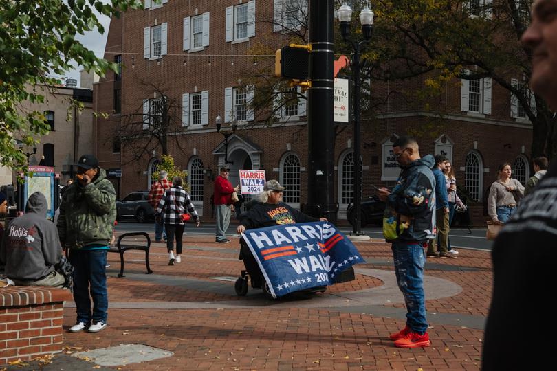 Douglas Wickenheiser, 67, holds a flag in support of the Harris-Walz ticket in downtown Lancaster. 