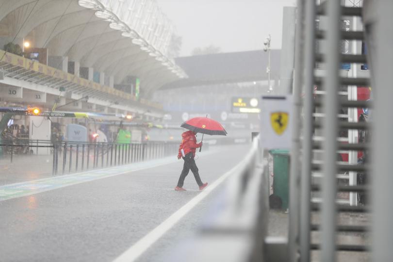 A Ferrari team member walks through pits after the qualifying session for the Brazilian Formula One Grand Prix has been postponed do to heavy rainfall at the Interlagos racetrack in Sao Paulo.