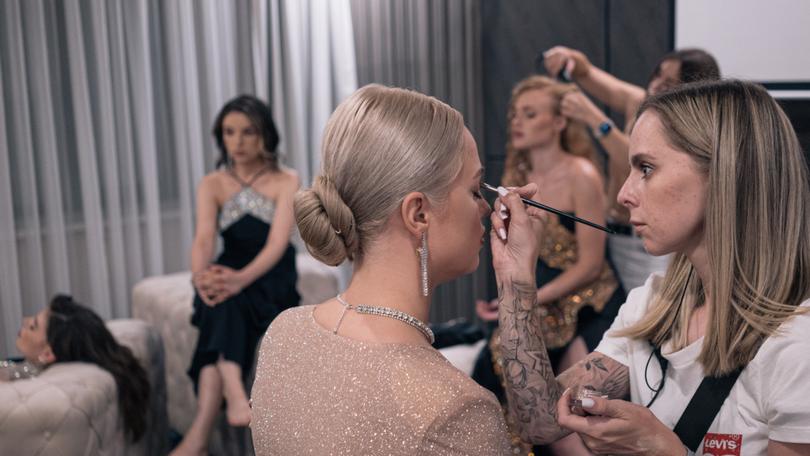 A makeup artist works on one of the participants of The Bachelor backstage. Alice Martins for The Washington Post