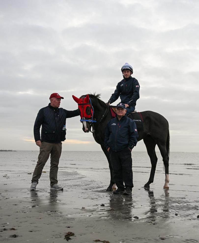 ALTONA NORTH, AUSTRALIA - NOVEMBER 04: Onesmoothoperator poses with trainer Brian Ellison (front) in preparation for tomorrows Melbourne Cup is seen during a beach session at Altona Beach on November 04, 2024 in Altona North, Australia. (Photo by Vince Caligiuri/Getty Images)