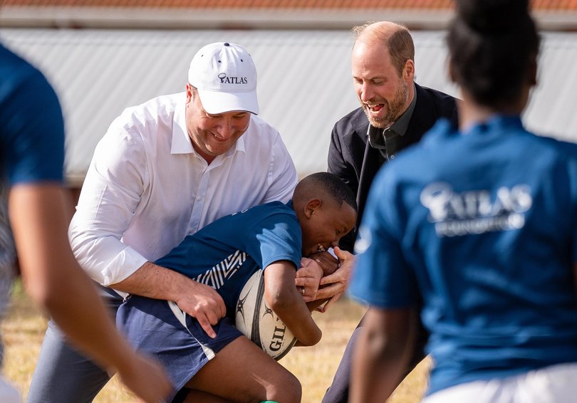 The Prince of Wales seems to be enjoying himself as he takes part in the rugby class.