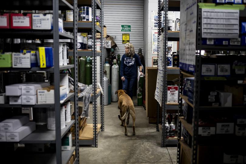 Lynne Gold pulls orders for customers on Oct. 24 as her dog, Huey, follows her. 