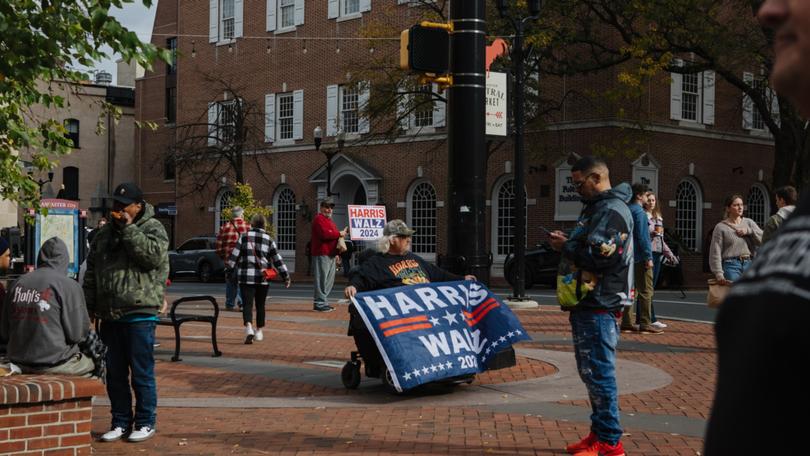 Douglas Wickenheiser, 67, holds a flag in support of the Harris-Walz ticket in downtown Lancaster, Pennsylvania on Oct. 26. 