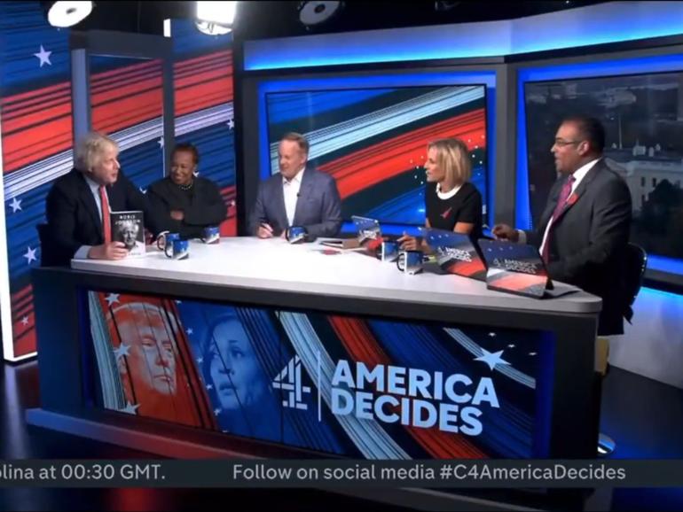 Boris Johnson holds up his book 'Unleashed' during an appearance on a panel during Channel 4's live coverage of the US election.