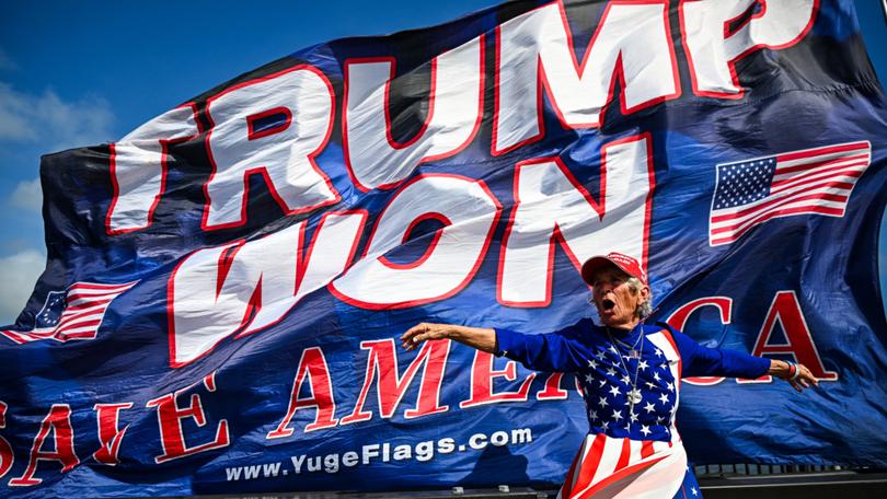 Supporters of former US president and Republican presidential candidate Donald Trump celebrate his victory near his Mar-a-Lago resort in Palm Beach, Florida, on November 6, 2024. - Donald Trump won a sweeping victory Wednesday in the US presidential election, defeating Kamala Harris to complete an astonishing political comeback that sent shock waves around the world. (Photo by CHANDAN KHANNA / AFP)