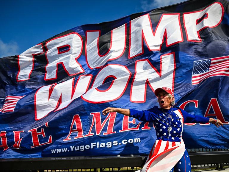 Supporters of former US president and Republican presidential candidate Donald Trump celebrate his victory near his Mar-a-Lago resort in Palm Beach, Florida, on November 6, 2024. - Donald Trump won a sweeping victory Wednesday in the US presidential election, defeating Kamala Harris to complete an astonishing political comeback that sent shock waves around the world. (Photo by CHANDAN KHANNA / AFP)