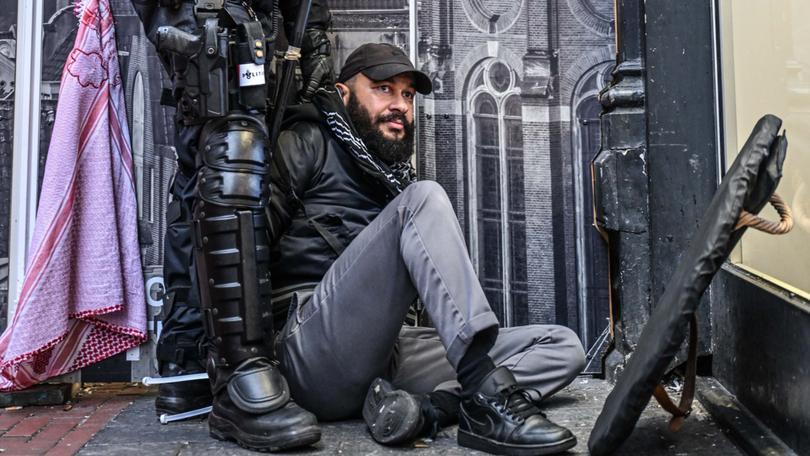 A police officer with one of the protesters in Amsterdam.