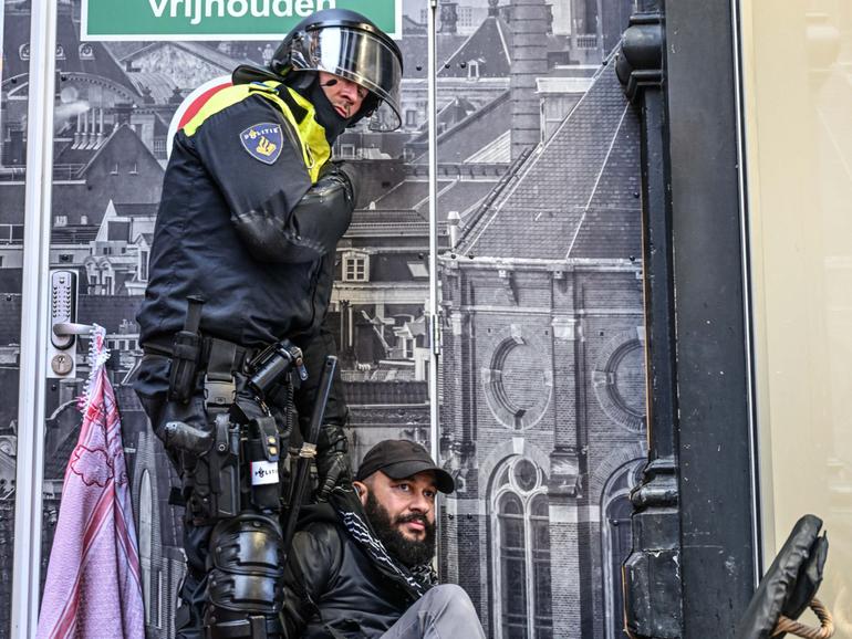 A police officer with one of the protesters in Amsterdam.