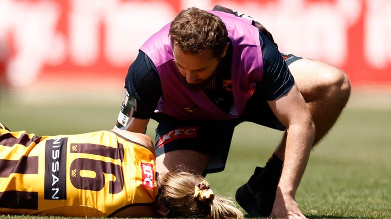 Ainslie Kemp is attended to by trainers after she was hit by Belle Dawes.