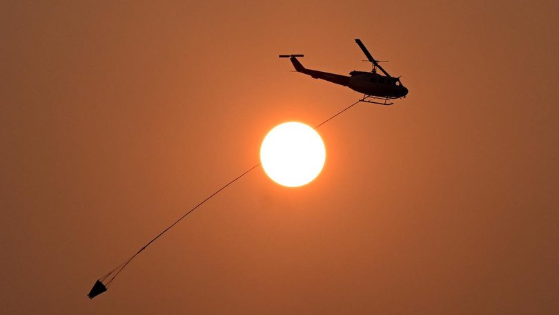 Fire crews and water bombing helicopters continue to battle a blaze northwest of Townsville.