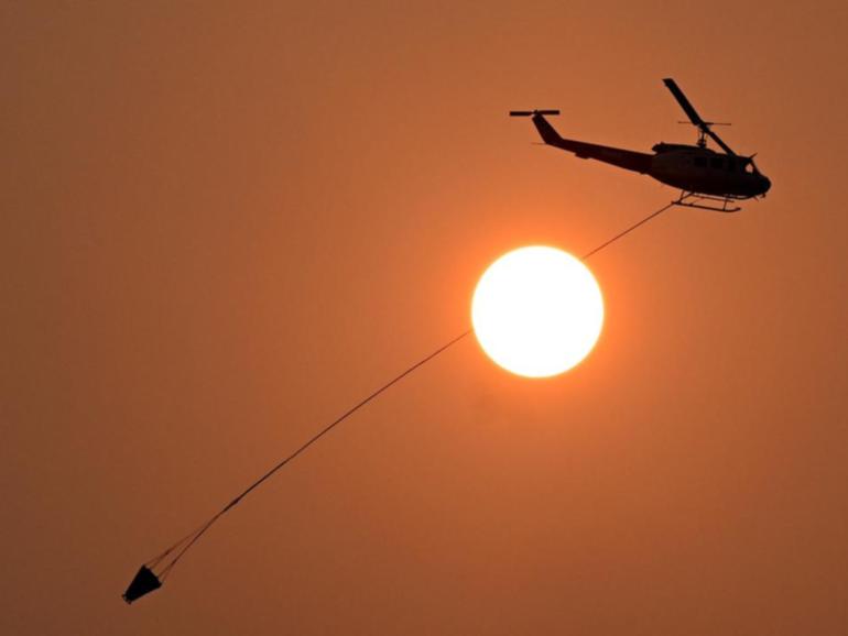 Fire crews and water bombing helicopters continue to battle a blaze northwest of Townsville.