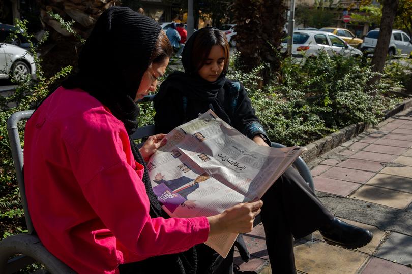 A woman in Tehran reads a newspaper story about Donald Trump’s victory in the U.S. presidential election on Thursday, Nov. 7, 2024. 