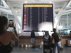 Passengers look at a flight information board at Ngurah Rai International Airport in Bali, Indonesia.