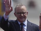 Australian Prime Minister Anthony Albanese and Peruvian Minister of Development and Social Inclusion Julio Demartini wave to the crowd in Lima, Peru.