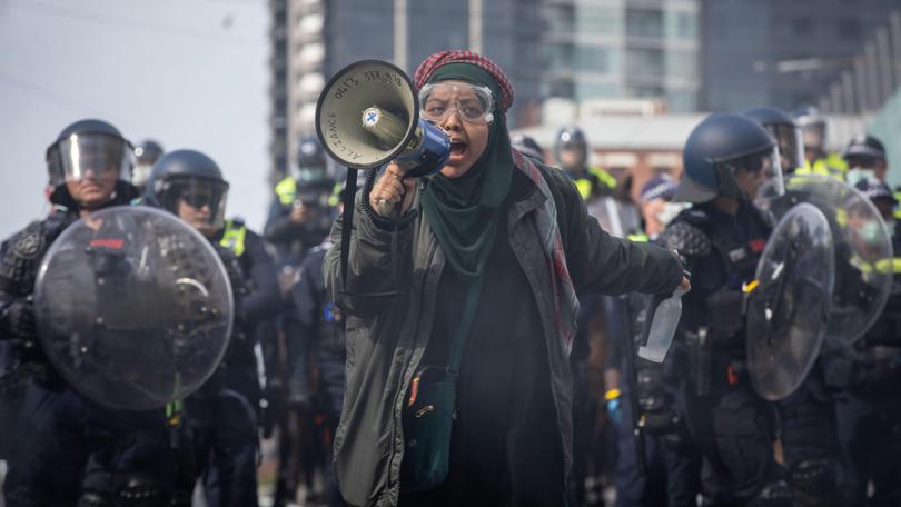 An anti-war protester speaks over a megaphone in Melbourne.