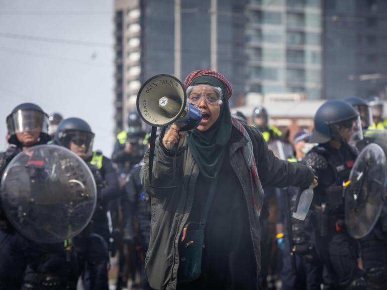 An anti-war protester speaks over a megaphone in Melbourne.  