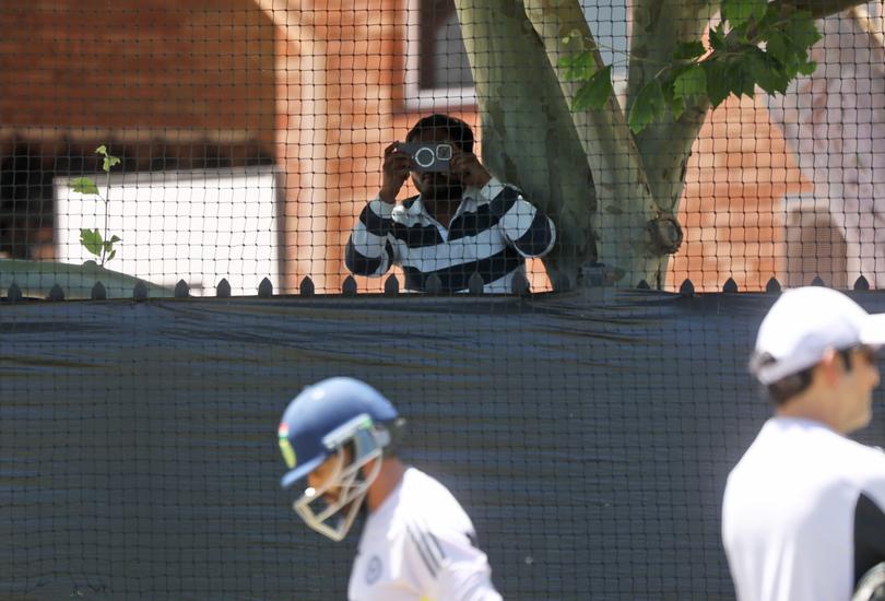 Fans climbs a tree outside the ground to look over the black tarp and watch the team train in the nets. The India Cricket Team during a training session at the WACA in Perth.