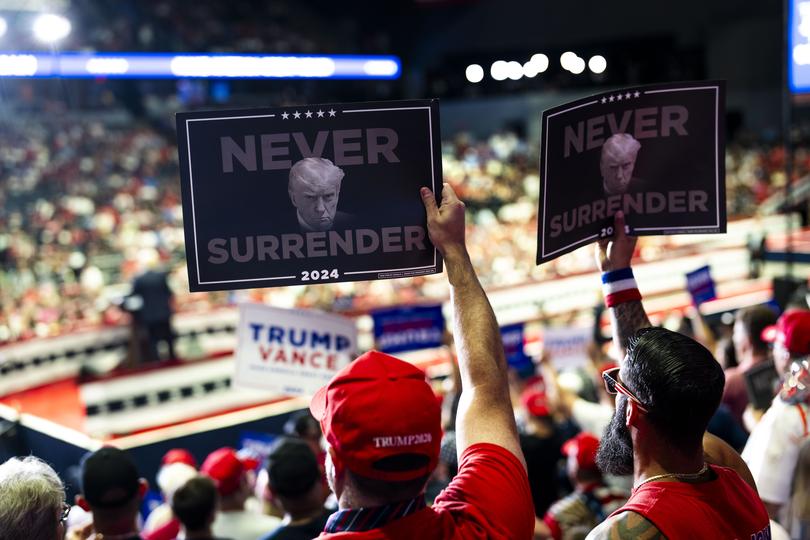 Supporters of former President Donald Trump hold signs at his campaign rally in Grand Rapids, Mich., on Saturday, July 20, 2024. 