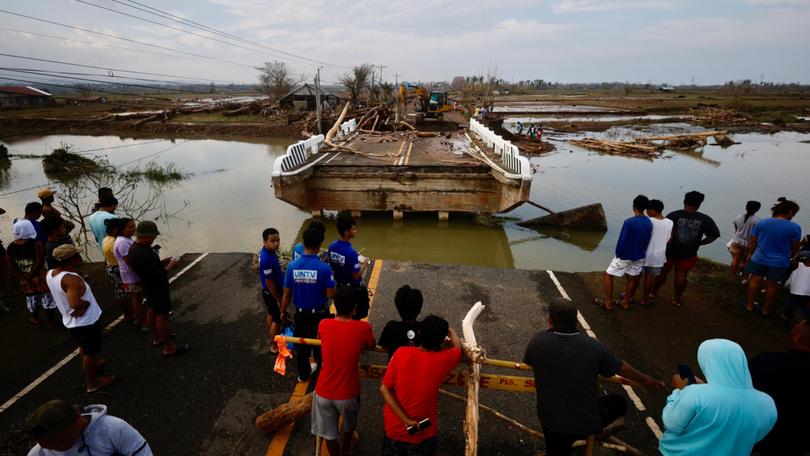 Filipino villagers look at a damaged bridge affected by Typhoon Usagi.