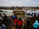 Filipino villagers look at a damaged bridge affected by Typhoon Usagi.