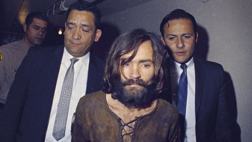 Charles Manson is escorted to his arraignment on conspiracy-murder charges in connection with the Sharon Tate murder case in Los Angeles in 1969. 