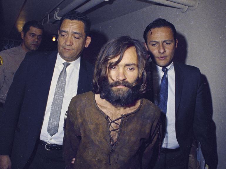 Charles Manson is escorted to his arraignment on conspiracy-murder charges in connection with the Sharon Tate murder case in Los Angeles in 1969. 