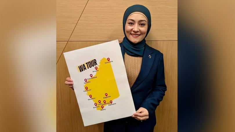 Senator Fatima Payman holding up a sign showing the locations she's going to visit on her tour of WA