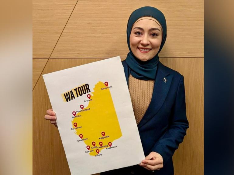 Senator Fatima Payman holding up a sign showing the locations she's going to visit on her tour of WA