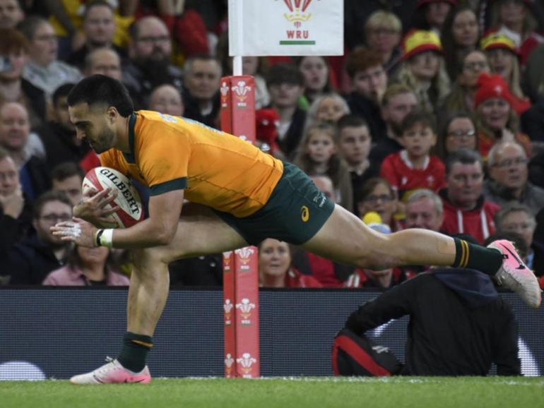 Tom Wright powering over for one of his three tries in the Wallabies' crushing win over Wales. (AP PHOTO)