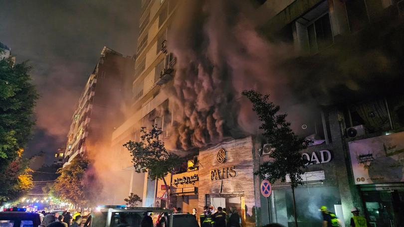 Civil defence workers extinguish a fire at the site of an Israeli airstrike in central Beirut.