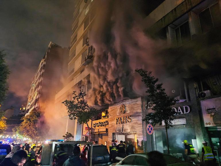 Civil defence workers extinguish a fire at the site of an Israeli airstrike in central Beirut.