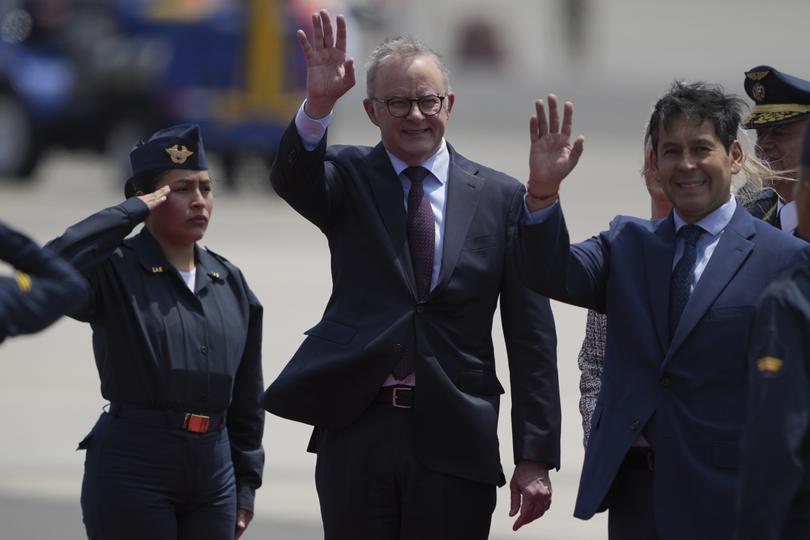 Australian Prime Minister Anthony Albanese and Peruvian Minister of Development and Social Inclusion Julio Demartini wave to the crowd in Lima, Peru.