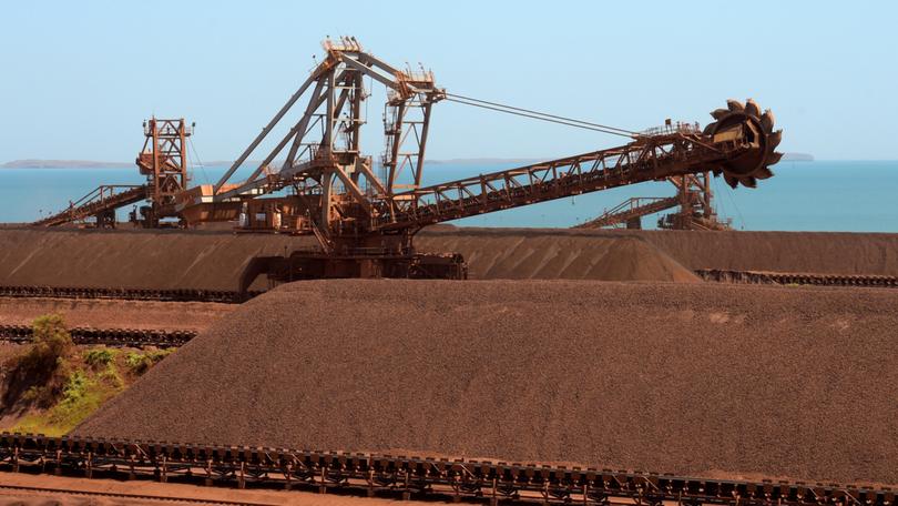 Iron ore stockpiles waiting to be transported at Rio Tinto Group's port facility in Karratha, Western Australia, on Friday, Oct. 20, 2023. Rio Tinto Group, BHP Group Ltd. and Fortescue Metals Group Ltd. produce almost two-thirds of the world’s seaborne iron ore from Western Australia, and margins remain enviable. For the first time in a generation, though, the specter of disruption looms over mining’s most reliable profit generator. Photographer: Carla Gottgens/Bloomberg