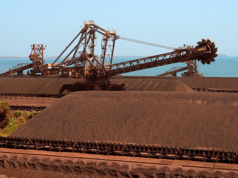 Iron ore stockpiles waiting to be transported at Rio Tinto Group's port facility in Karratha, Western Australia, on Friday, Oct. 20, 2023. Rio Tinto Group, BHP Group Ltd. and Fortescue Metals Group Ltd. produce almost two-thirds of the world’s seaborne iron ore from Western Australia, and margins remain enviable. For the first time in a generation, though, the specter of disruption looms over mining’s most reliable profit generator. Photographer: Carla Gottgens/Bloomberg