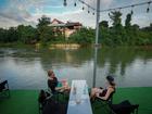 Foreign tourists drink beer at a bar near a river in Vang Vieng, Laos.