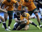 Australia's Noah Lolesio is tackled by Scotland's Scott Cummings.