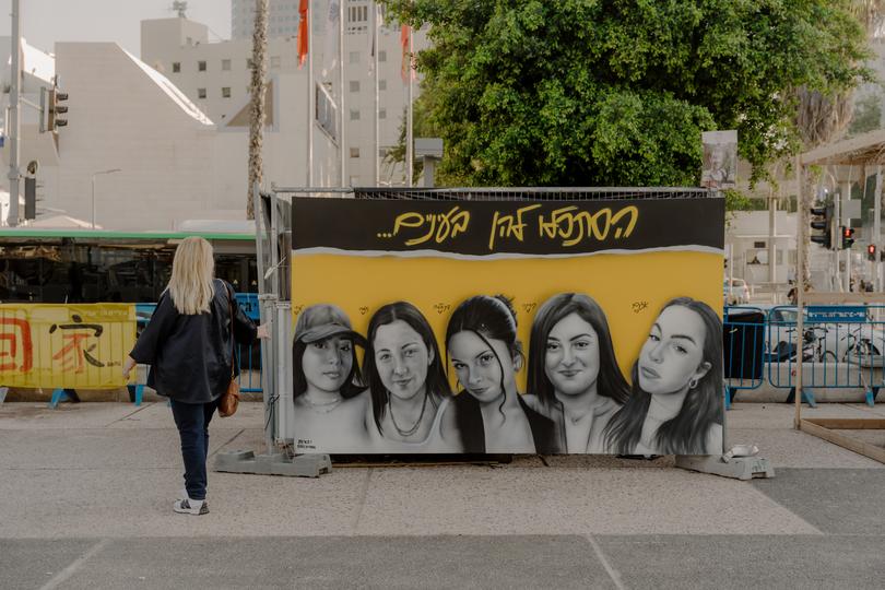 A sign in Tel Aviv's Hostage Square featuring five kidnapped female soldiers. It reads: "Look them in the eyes.” 