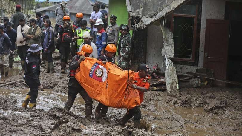 Rescuers carry the body of a victim of flooding in Karo, North Sumatra.