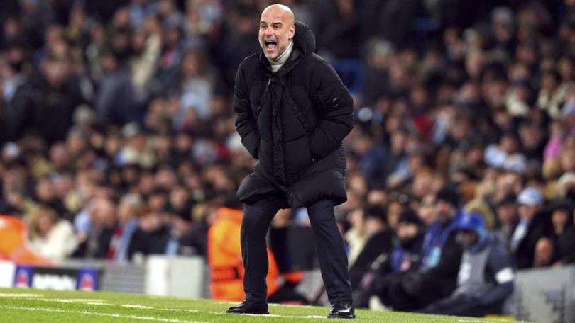 Manchester City manager Pep Guardiola shouts encouragement to his team from the sidelines.