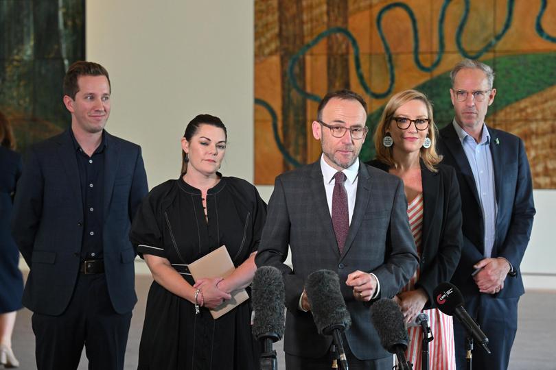 Greens leader Adam Bandt and fellow party members celebrate their $500 million commitment from the Labor Government. 