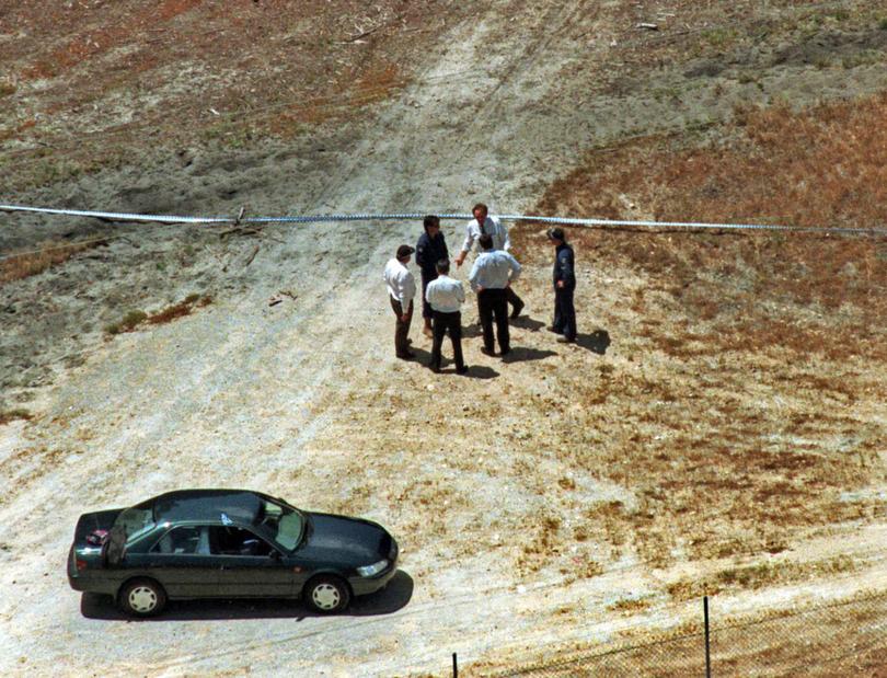 Police discuss the body found in the pine plantation near Baldivis road today.