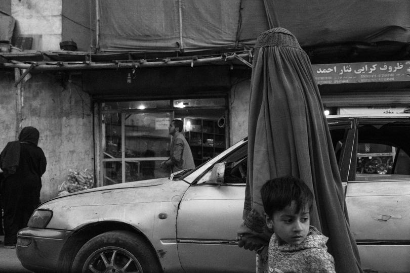 A woman in a burqa walks with her son through Kabul in October. 