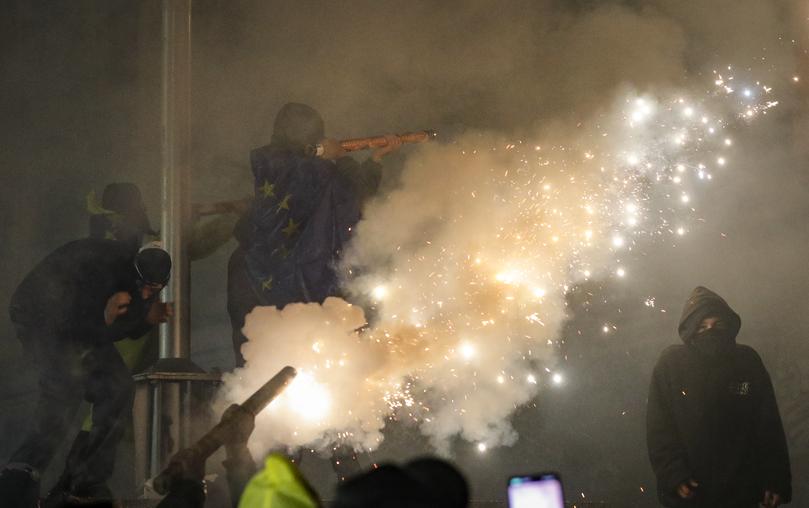 Georgian opposition supporters launch fireworks towards the Parliament building.