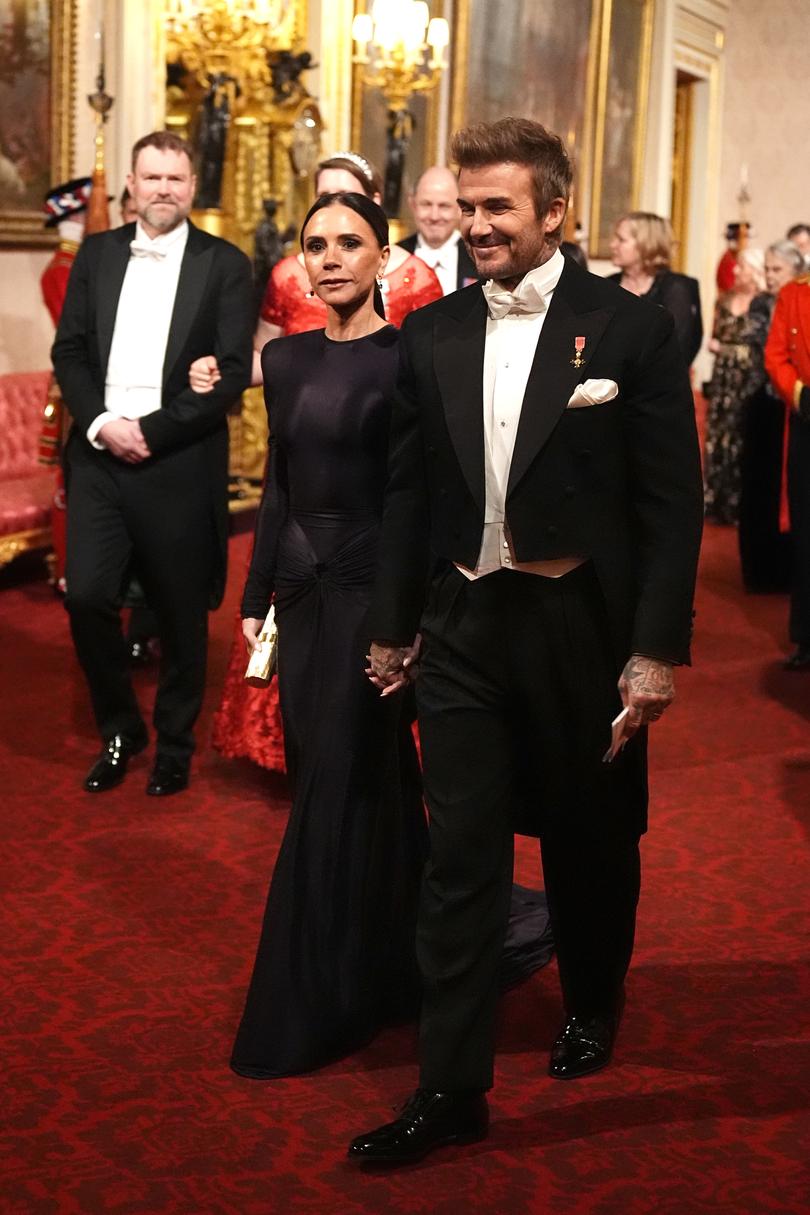 Victoria and David Beckham make their way along the East Gallery to attend the State Banquet at Buckingham Palace.