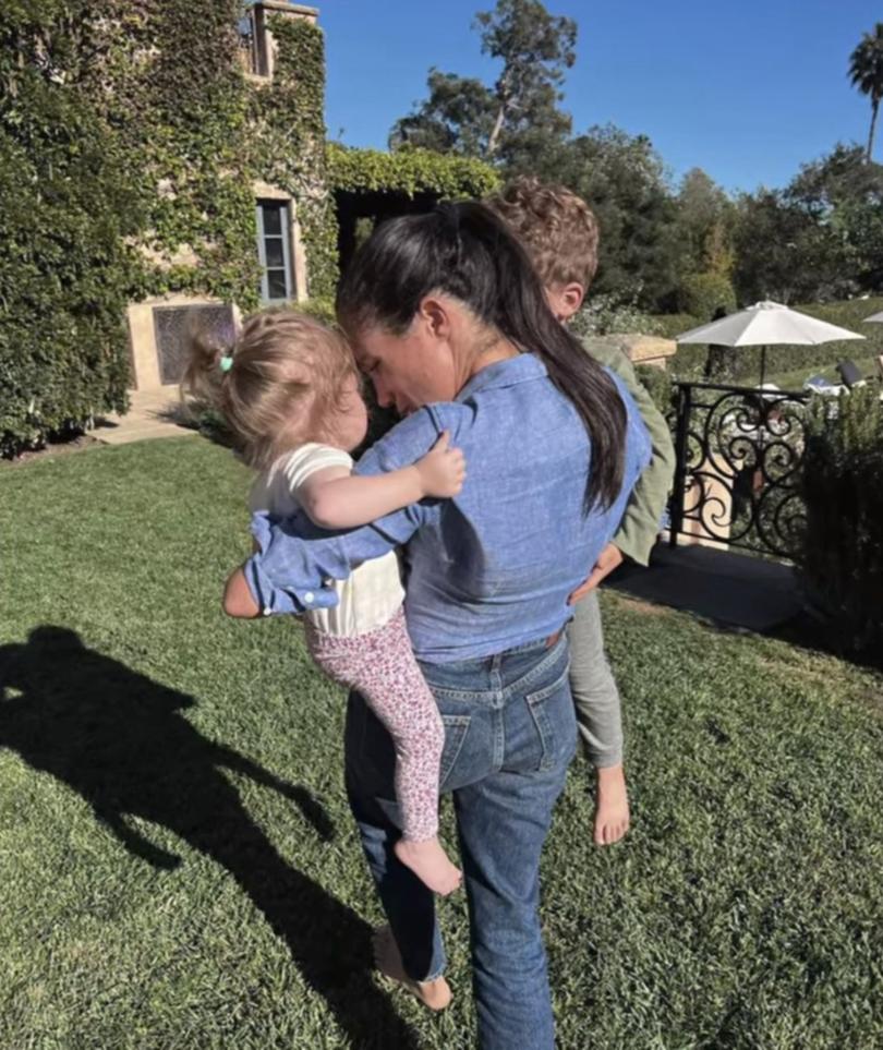 Meghan, Duchess of Sussex holding Prince Archie and Princess Lilibet.