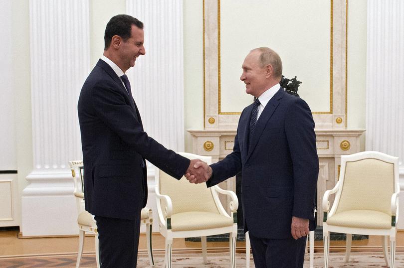 Russian President Vladimir Putin shakes hands with Syrian President Bashar al-Assad during their meeting in Moscow in September 2021.