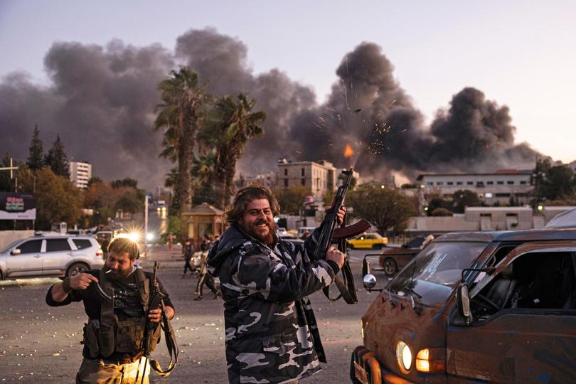 People shoot in the air as they celebrate the fall of the Syrian government in Damascus, Syria.